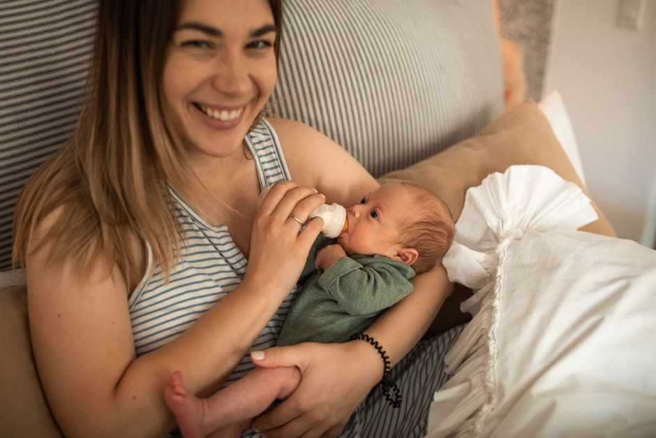 Mother cradling comfortable baby after a successful, peaceful bottle feed