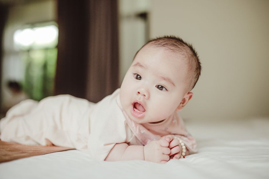 A peaceful baby resting comfortably on a soft bed