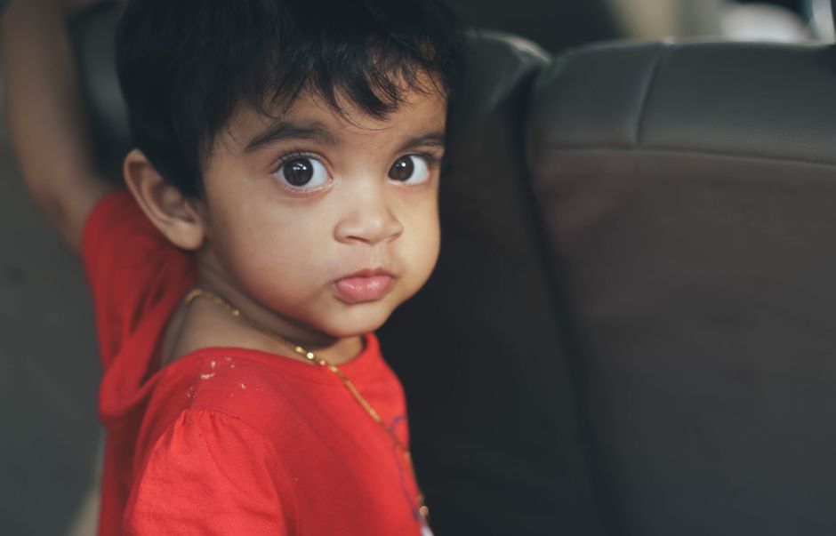 A baby with big bright curious eyes looking attentively ahead