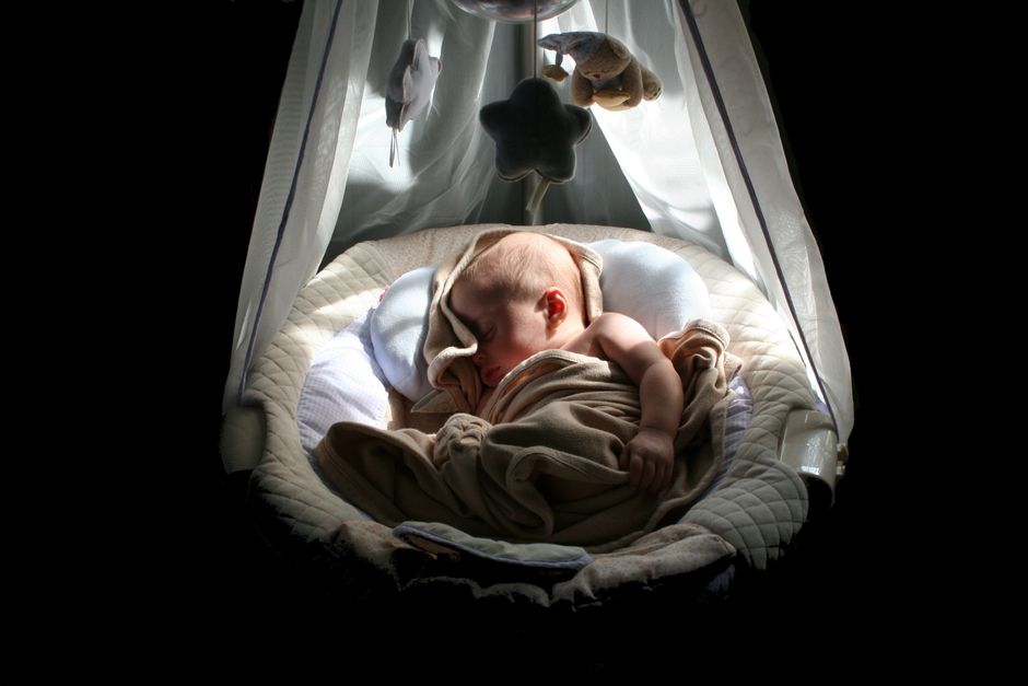 A calm baby sleeping soundly in a cozy, safe crib during evening bedtime