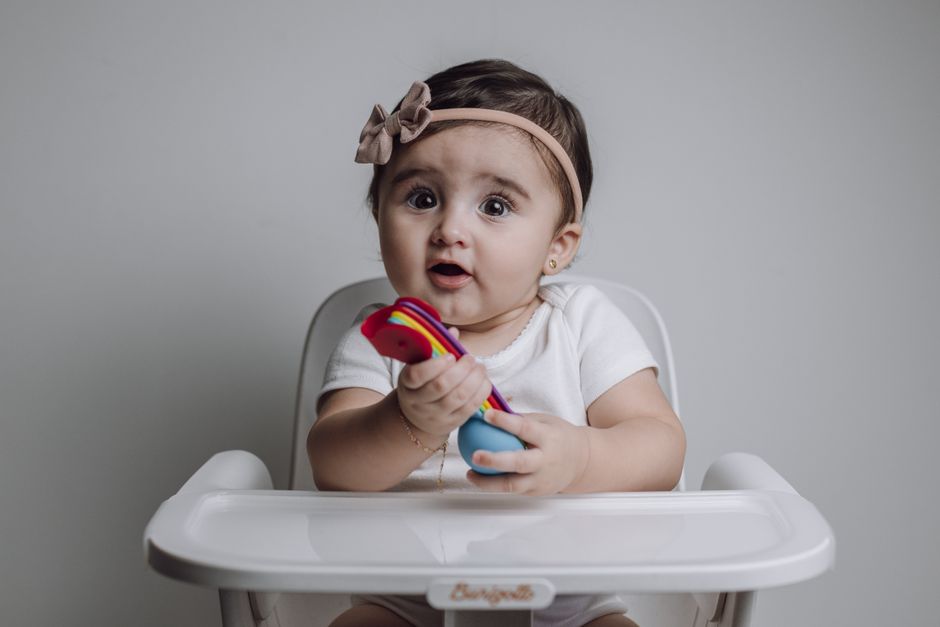 A baby sitting securely in an ergonomic high chair at mealtime