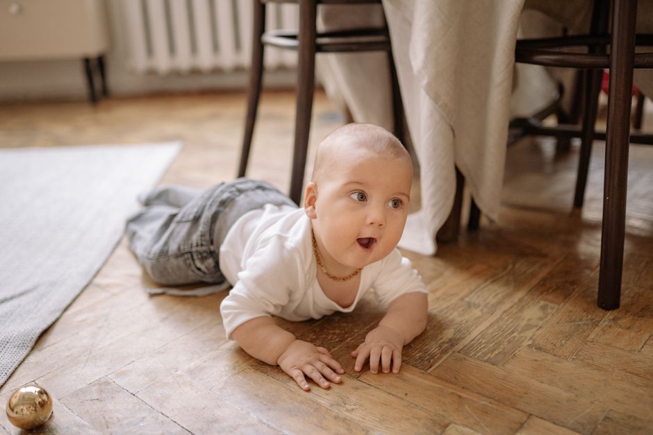 A baby happily crawling across a bright nursery floor