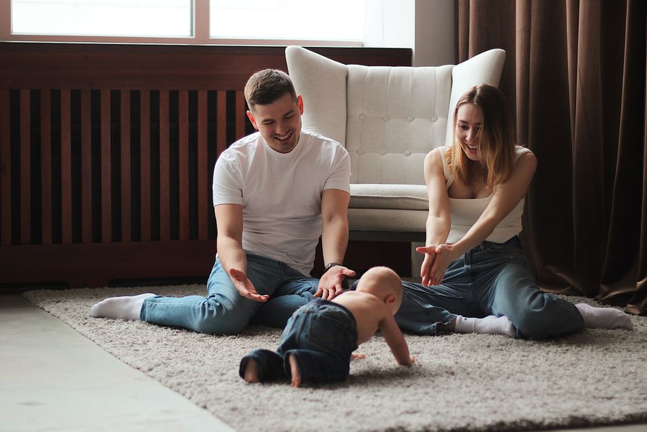 Young family enjoying playtime with their baby on a cozy living room rug without restrictive knee pads