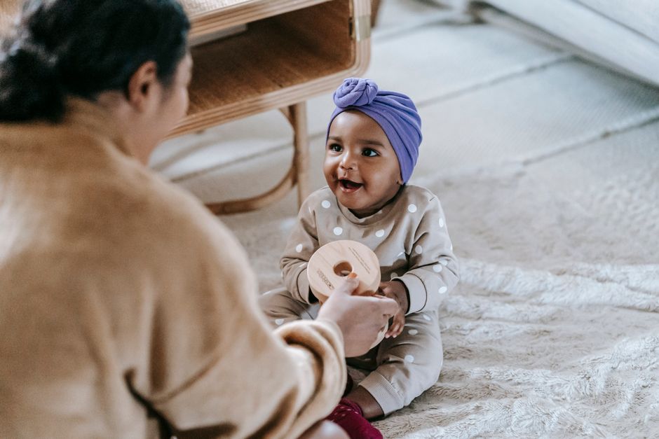 Mother smiling and engaging in face-to-face speech play with baby