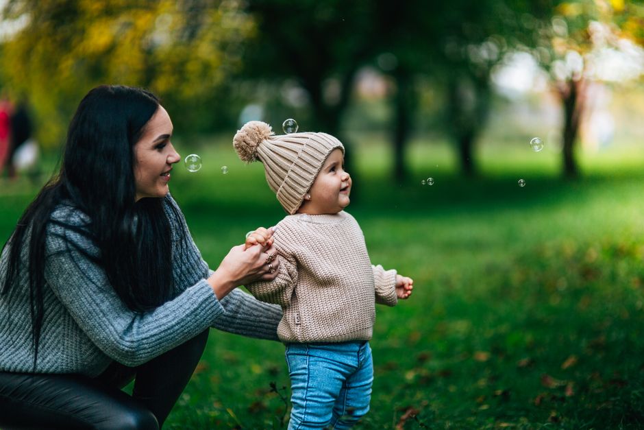 Mother smiling and engaging baby on playmat