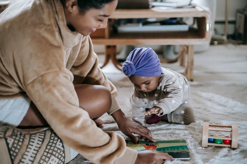 Mother playing with daughter on living room carpet in positive interaction