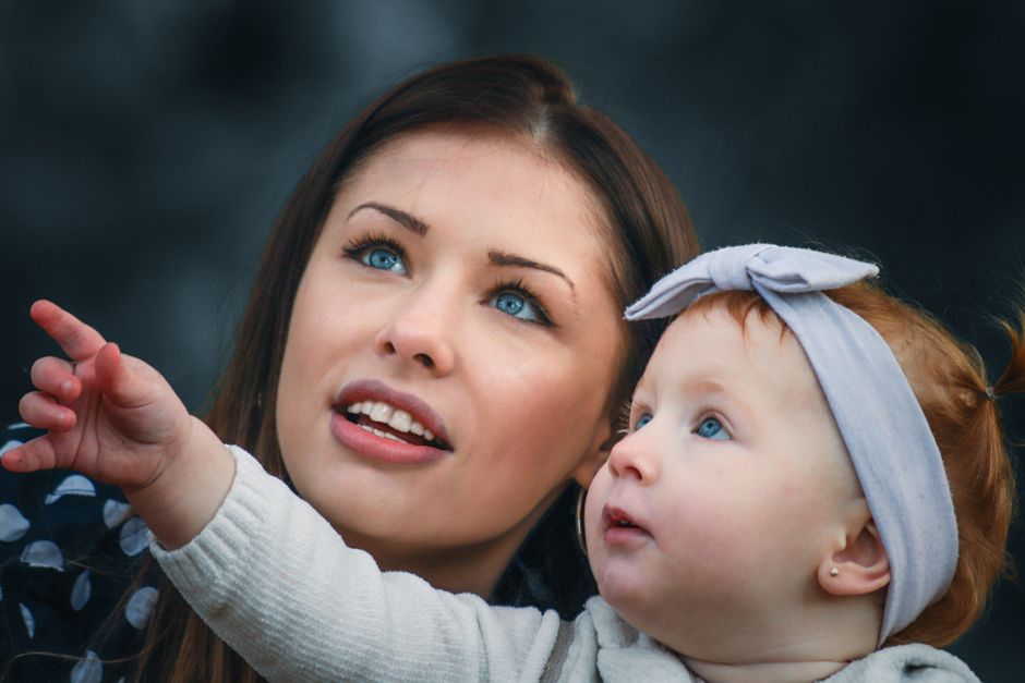 A touching portrait of a mother and baby engaging with curiosity