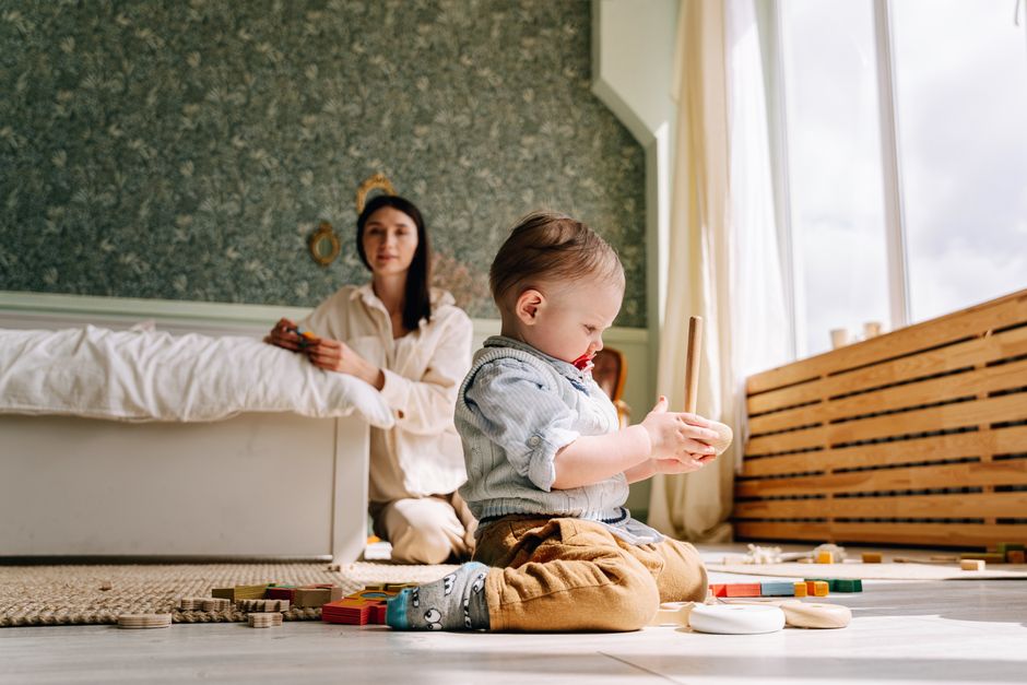 A mother engaging in interactive developmental floor play with her baby