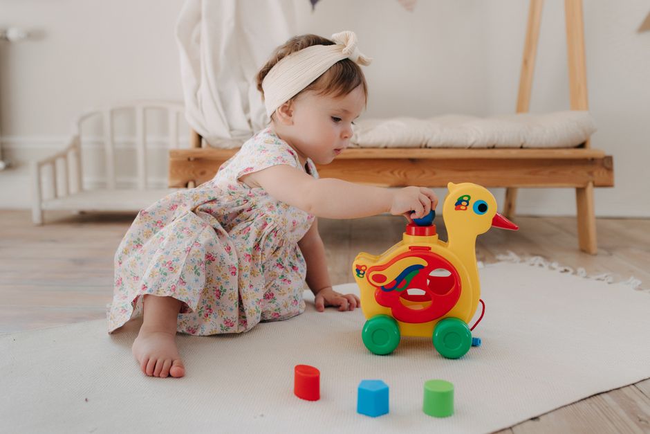 A happy toddler engaged in cheerful sensory play with colorful toys
