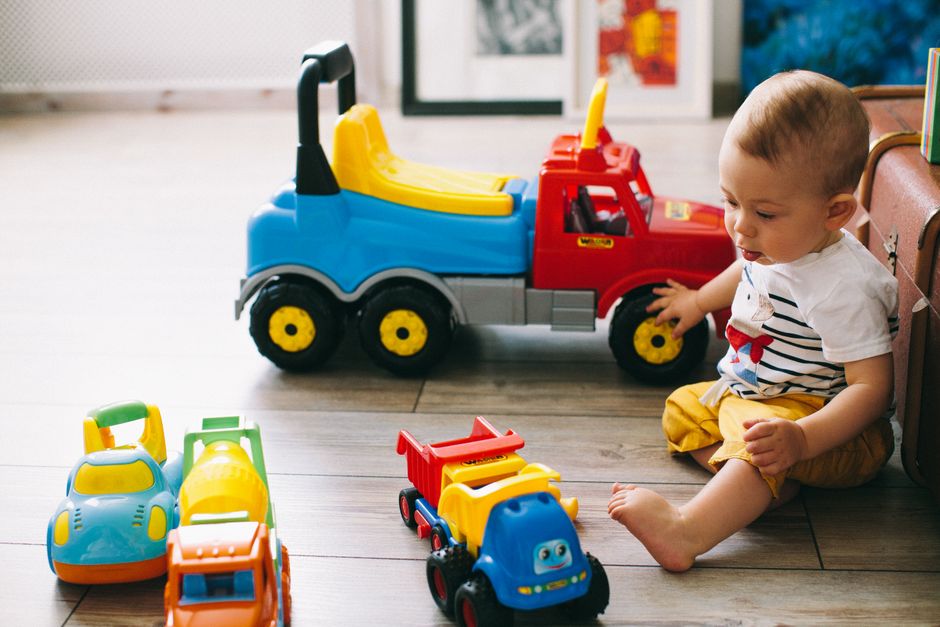 Cute baby boy enjoying playtime with colorful toy blocks on floor mat