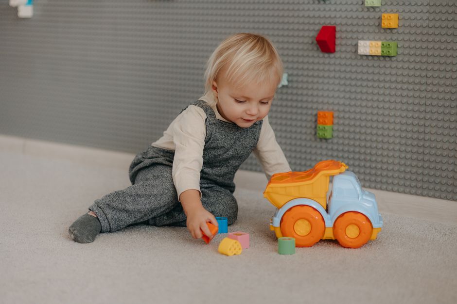 Cute toddler engaged with colorful blocks and toys indoors