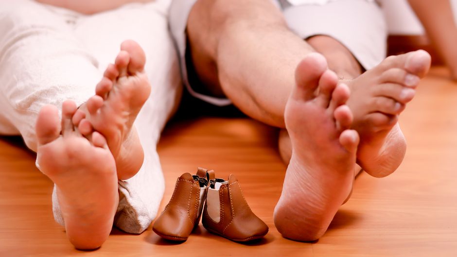 A family anticipation captured with bare feet and tiny baby shoes
