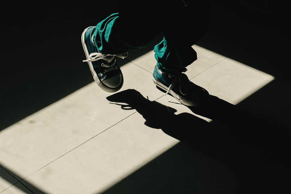 Silhouette of a child walking in sunlight with sneakers