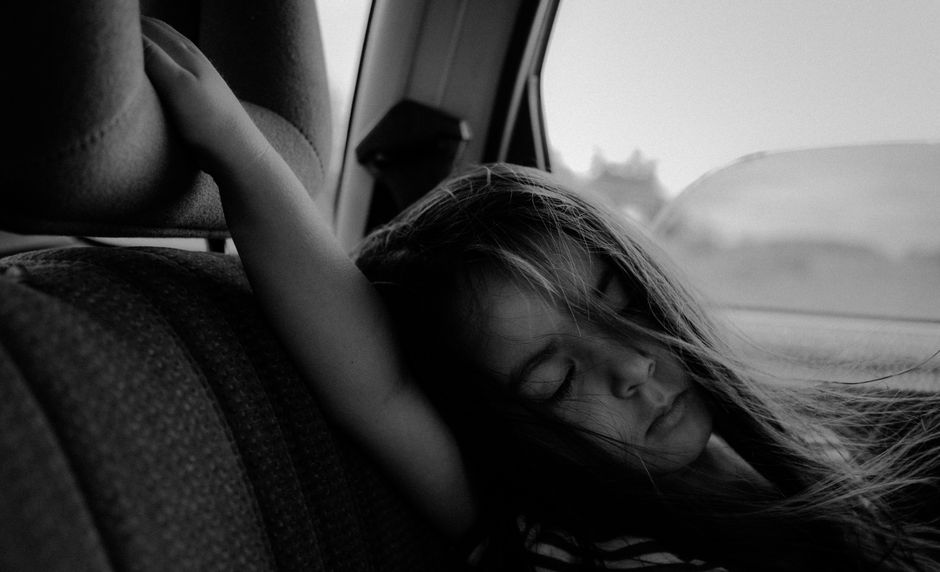A young girl peacefully asleep in a properly installed car seat