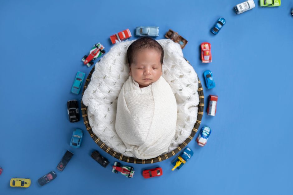 An adorable newborn baby resting safely on a flat surface