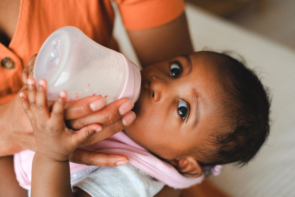 A caring mother gently burping and comforting her newborn after a milk feeding