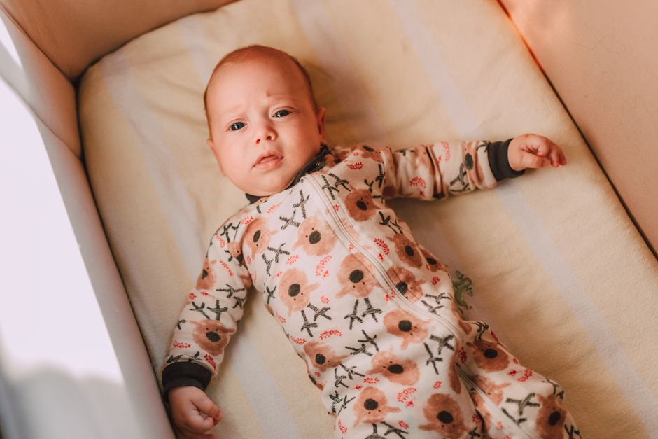 A baby awake and alert in the crib during the middle of the night