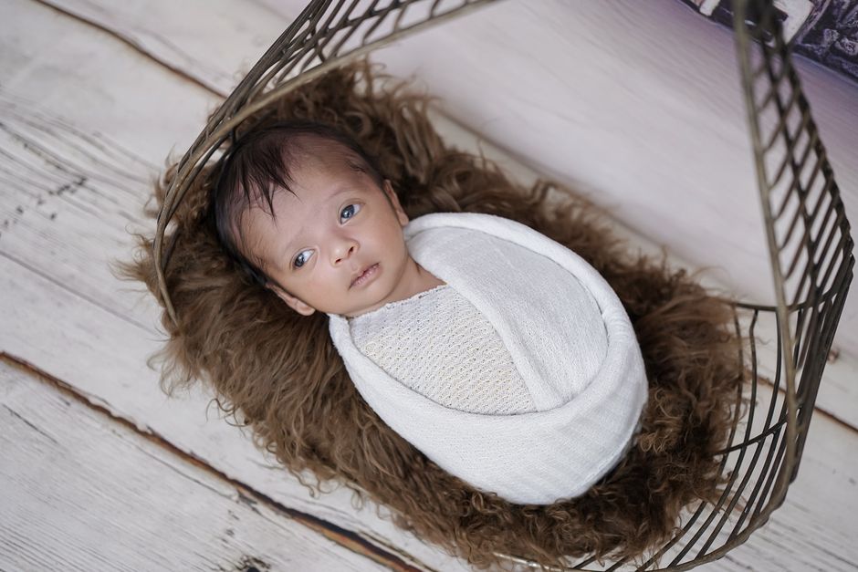 Top view of a baby resting in nursery crib in soft lighting