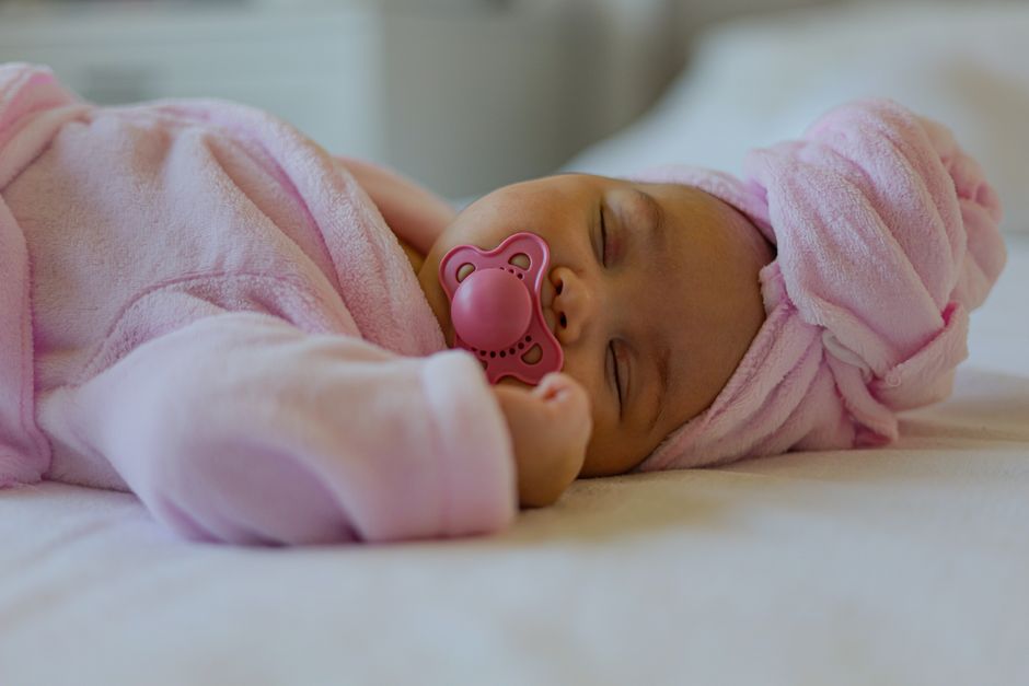 A serene baby sleeping peacefully with pacifier in nursery