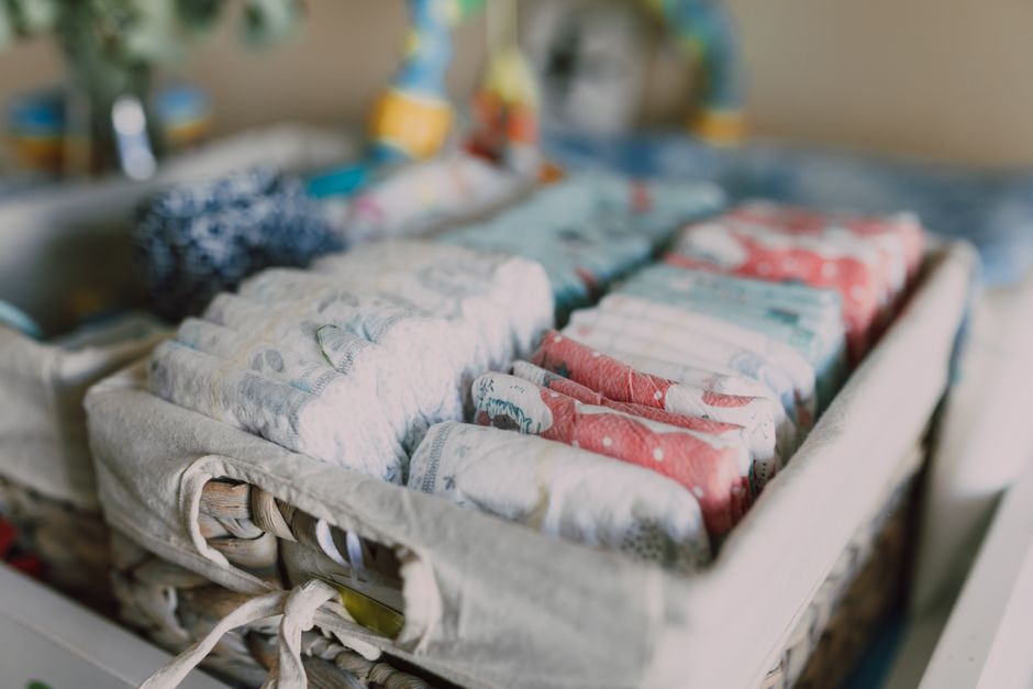 Organized baby diapers in a woven nursery storage basket