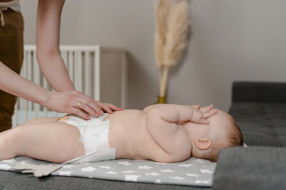 Baby resting calmly on changing pad during diaper care