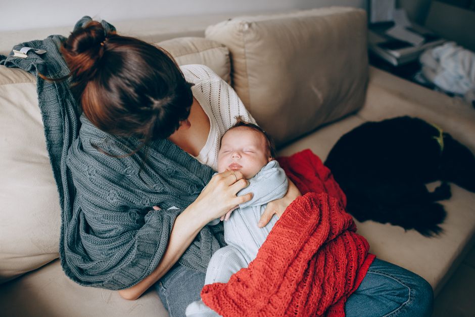 A mother resting comfortably with her newborn baby during postpartum recovery