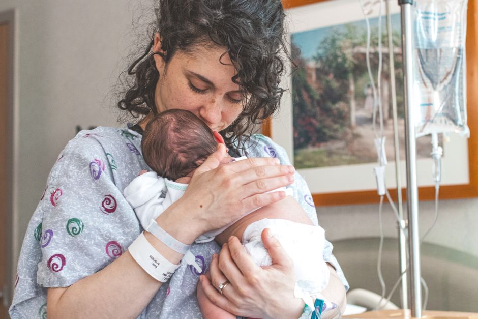 A mother tenderly holding her newborn baby in a restful setting