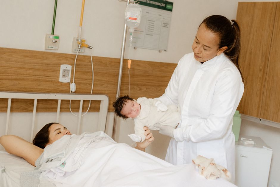 A healthcare professional supporting a new mother during clinical consultation