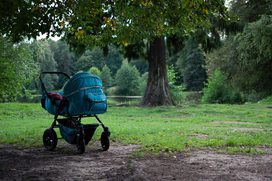 Baby stroller positioned safely in the shade during a warm summer day