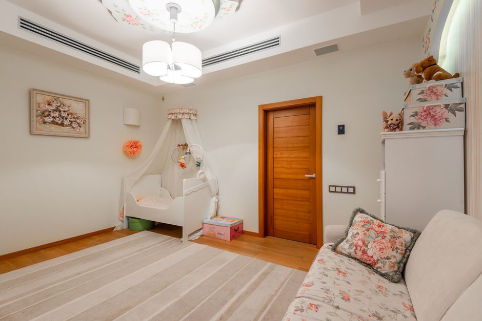 A serene and safely arranged modern baby nursery with a compliant wooden crib