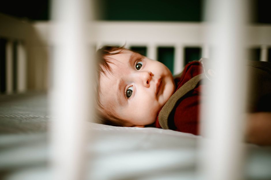 Toddler resting safely in a comfortable nursery crib without aftermarket hazards