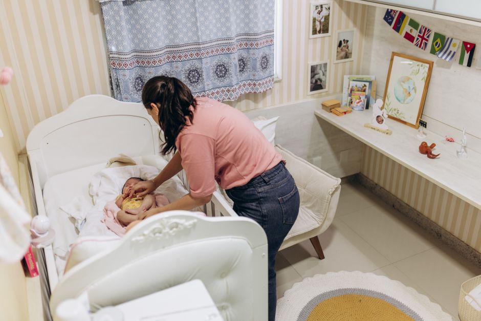 A mother tends to her baby in a cozy nursery, capturing a tender moment