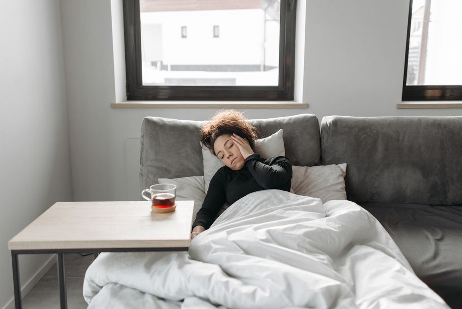 A woman resting on a couch indoors taking a gentle wellness moment