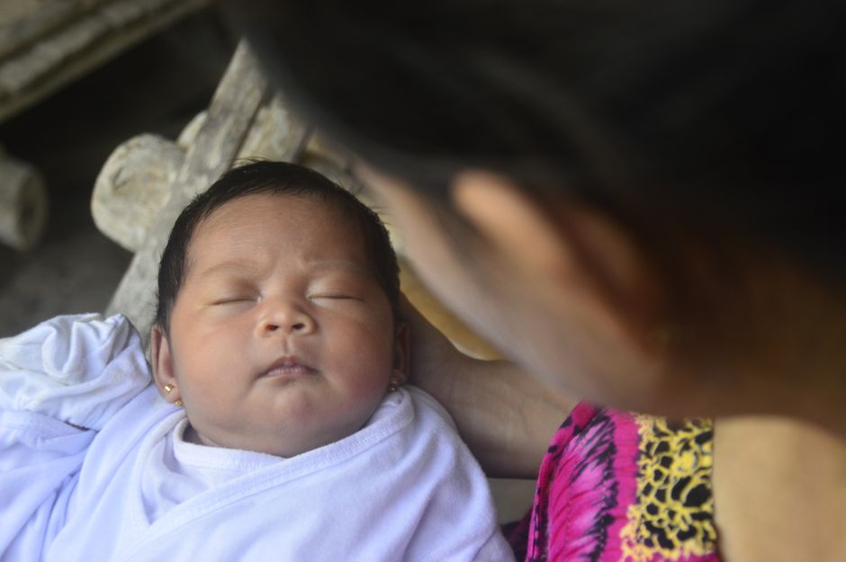 Mother holding infant baby close with affection and vigilance