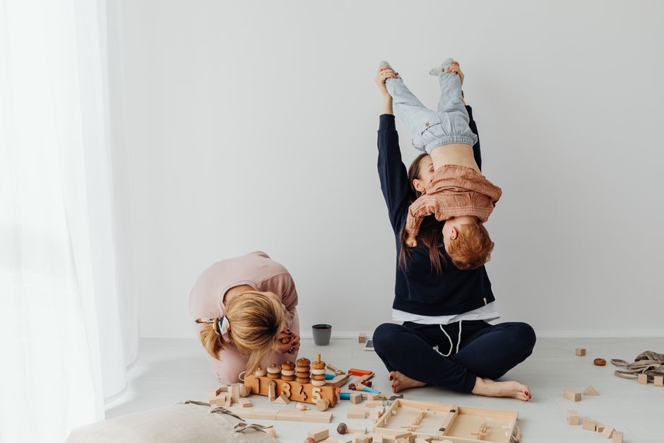 Family enjoying playful moments with children in a cozy indoor setting.