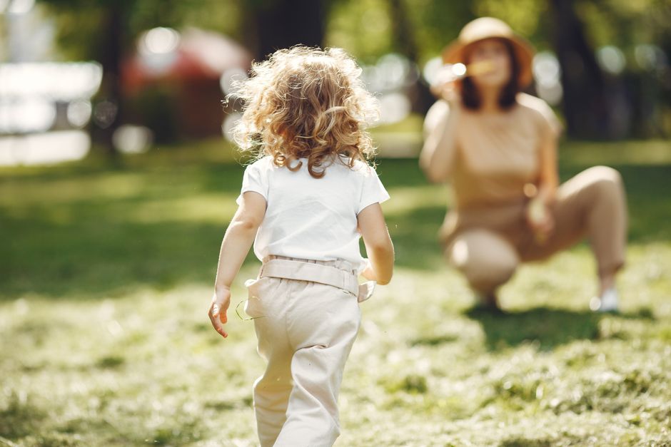 Low-angle shot of a young child's tiny feet walking outdoors with gentle steps