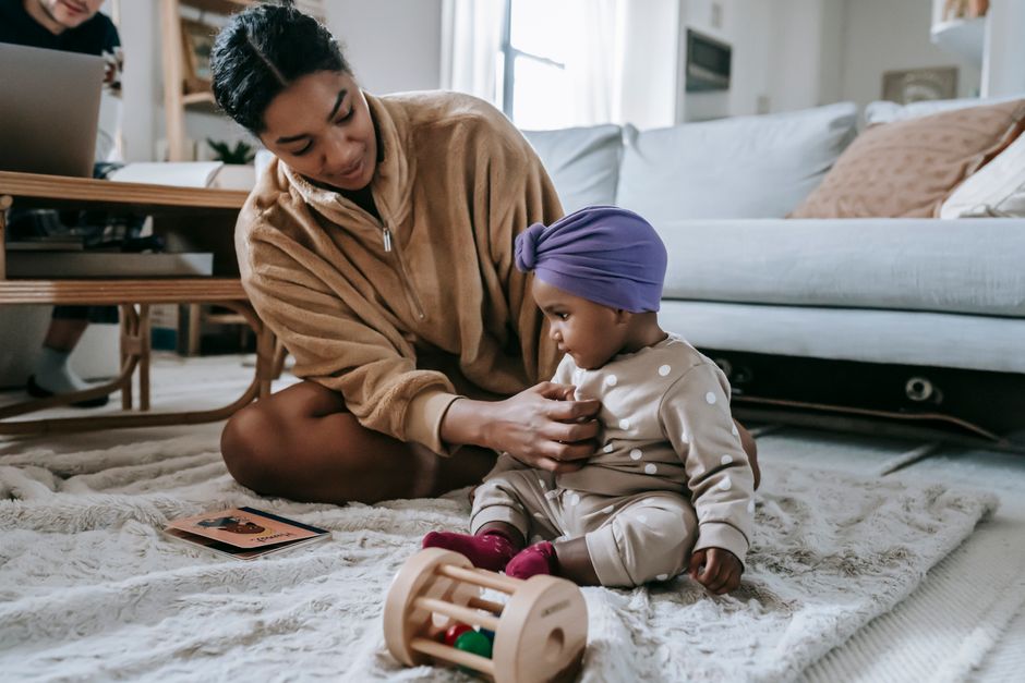 Mother calmly connecting and co-regulating with her toddler on the floor