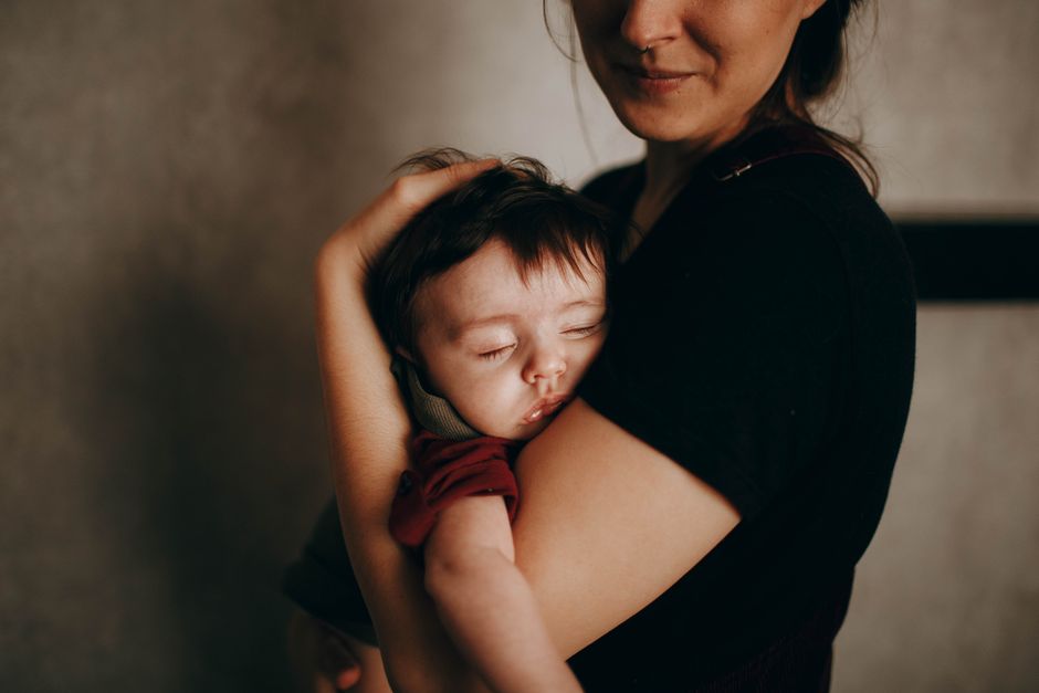 Mother holding and calming sleeping toddler in a peaceful bedroom setting