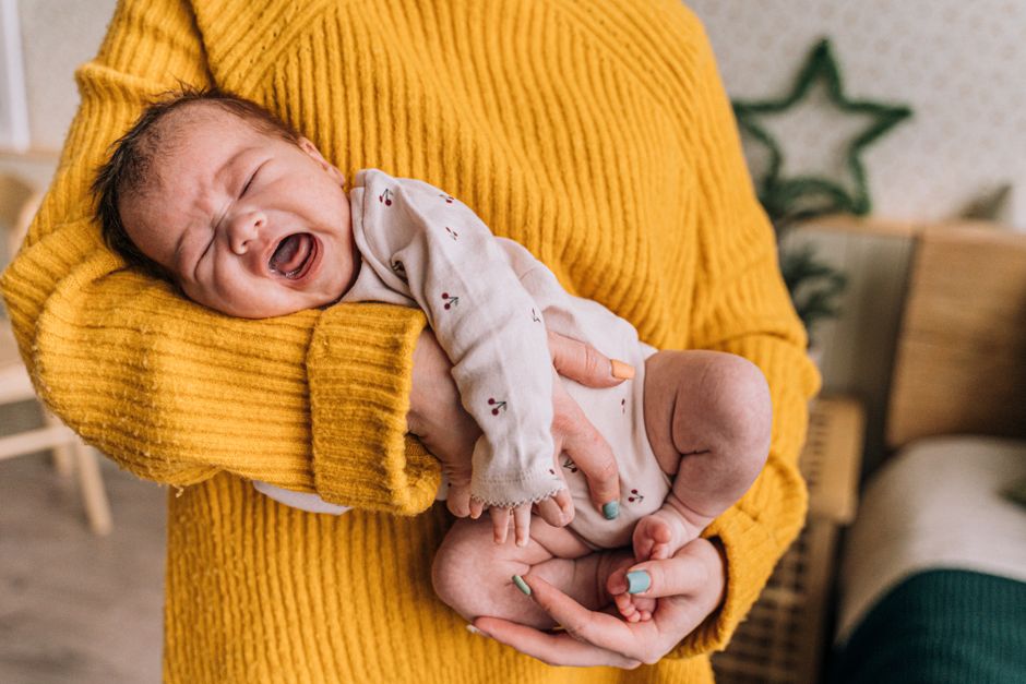 A caring mother gently rocking and comforting her fussy baby in a dimly lit nursery