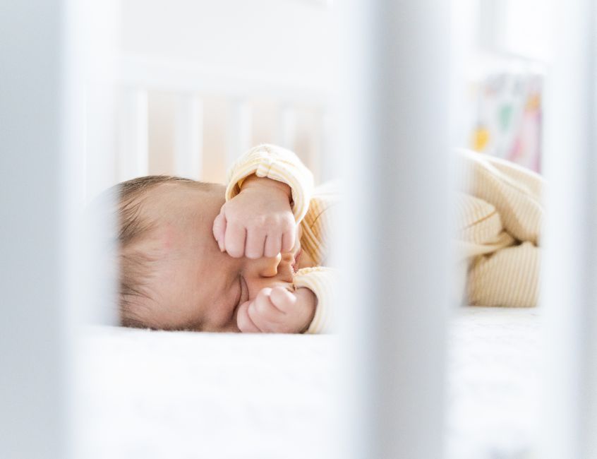 Newborn resting safely in a bright, modern nursery