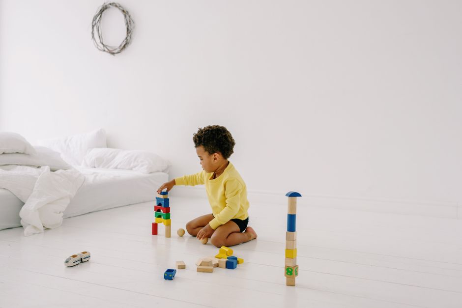 Young toddler engaged in peaceful floor play with tactile wooden blocks