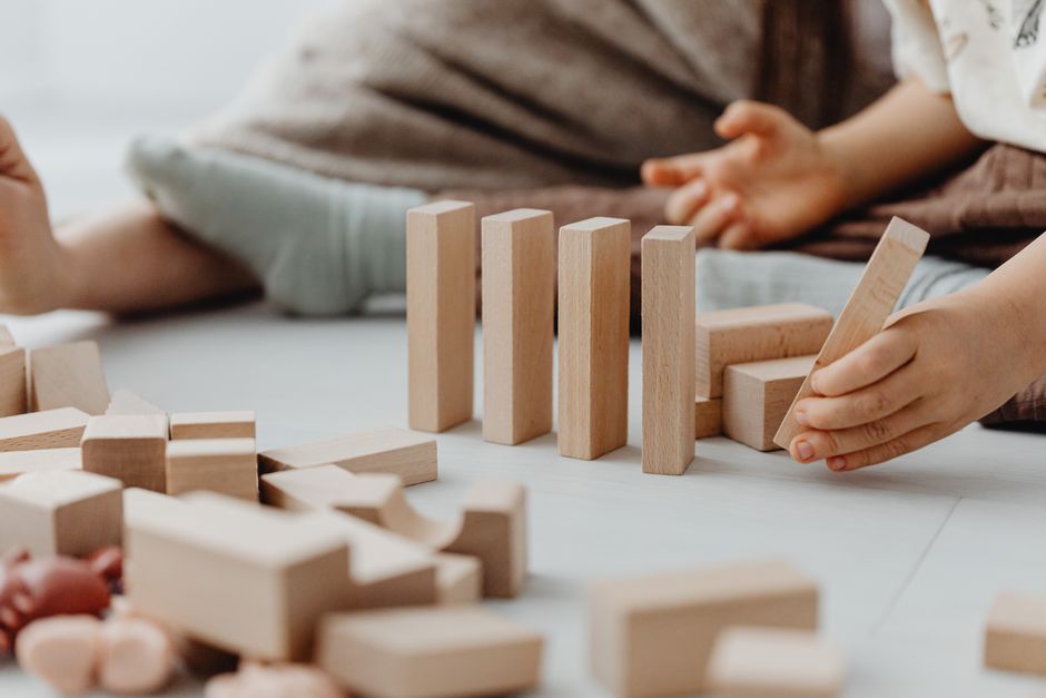 Toddler working with wooden blocks developing motor skills