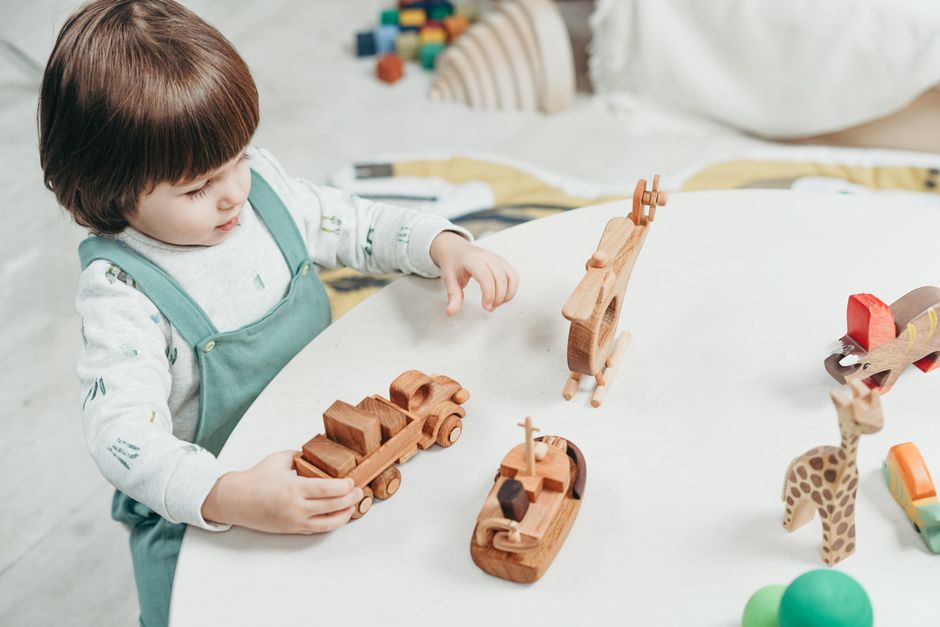 Young child playing at table with tactile toys in bright playroom