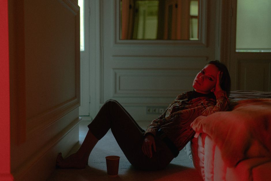 A mother resting pensively in a cozy, quiet bedroom setting