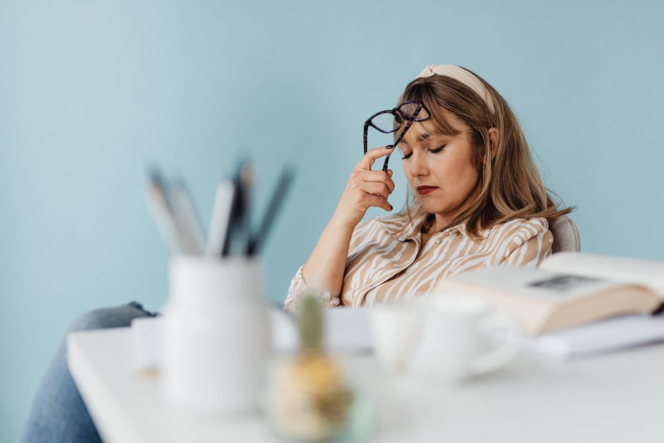 Exhausted mother resting head at desk during a quiet break