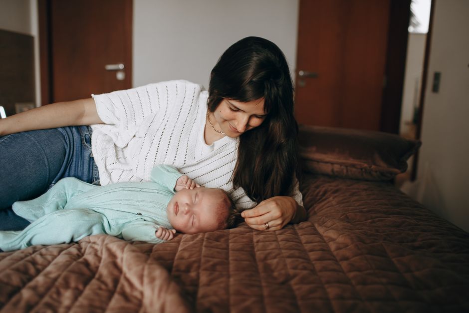 Mother tenderly watching her sleeping baby in a serene bedroom setting