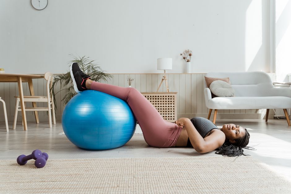 A mother stretching gently on a yoga mat with her baby