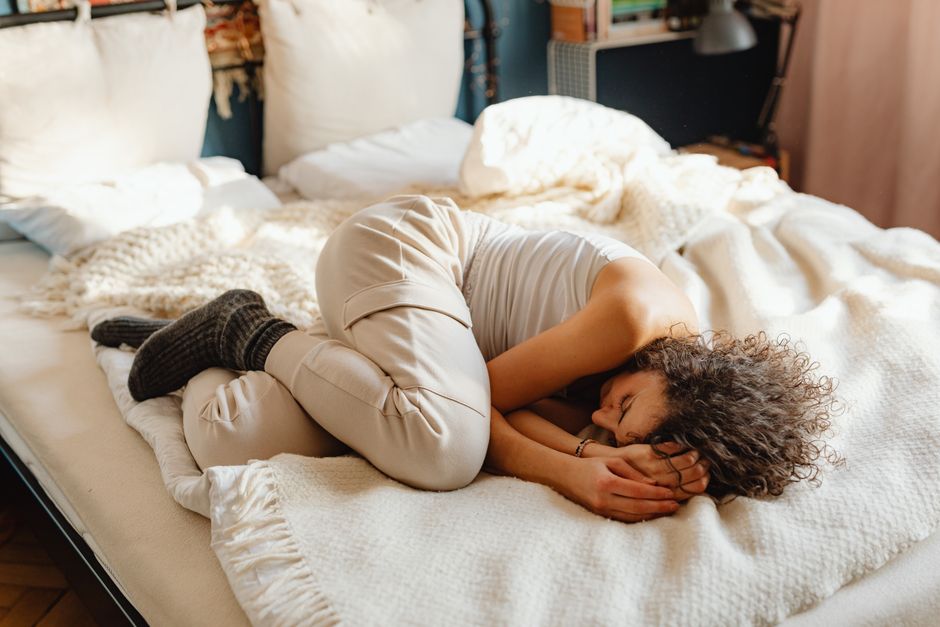 A mother resting peacefully in bed during gentle postpartum healing