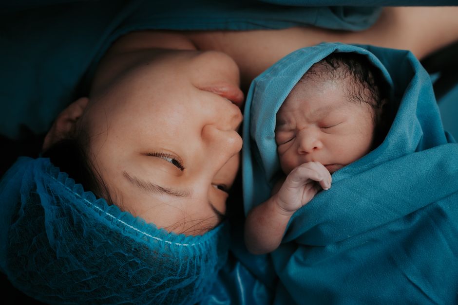 Mother holding her newborn taking a gentle wellness moment