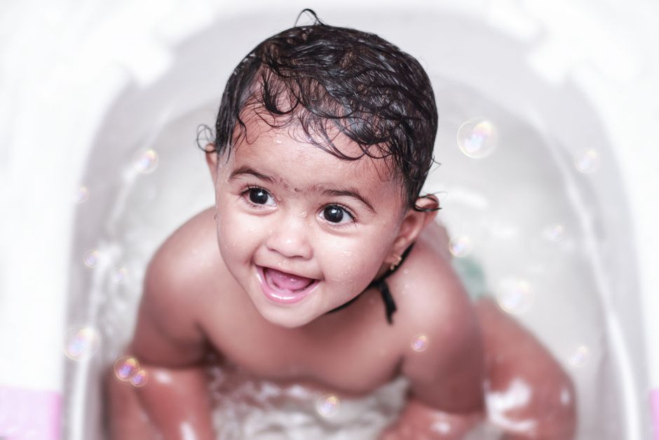 Adorable baby enjoying a bath with bubbles, showcasing a joyful smile and playful expression